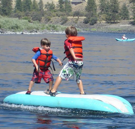 Children playing on inflatable kayak on a Hells Canyon whitewater raft trip