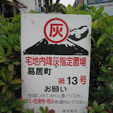 A common sign on the sidewalks of Kagoshima City, instructing residents and shopowners to bag the volcano ash they sweep up, and leave it by the sign for collection
