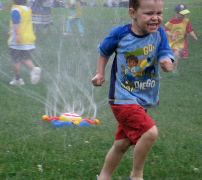 BigE running through the water sprinkler