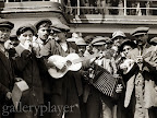 Original caption: Immigrant form a makeshift band on shipboard during trip to America. Photo by Lewis Hine.
