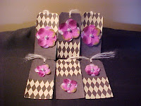 These tags are covered with scrapbook papers. I have added fabric flower petals with a vintage pearl as the center. Of course, I had to put alittle glitter on it too! Size is 5 1/4" X 2 5/8" and are blank on the back.