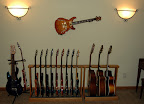 New home for my guitars (what, no couch?)... PRS Hollowbody II (on the wall); L to R: EB MM John Petrucci 6-string, EB MM John Petrucci 7-string, Dean Evo 7, PRS McCarty Rosewood, PRS McCarty Soapbar, PRS Singlecut, PRS Standard 24, (4) PRS Custom 24’s, PRS EG-1, Takamine EF-385 12-string acoustic, Guild DC5E-NT acoustic, Guild F47M-CE acoustic