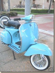 vespa motor scooter curb side blue
